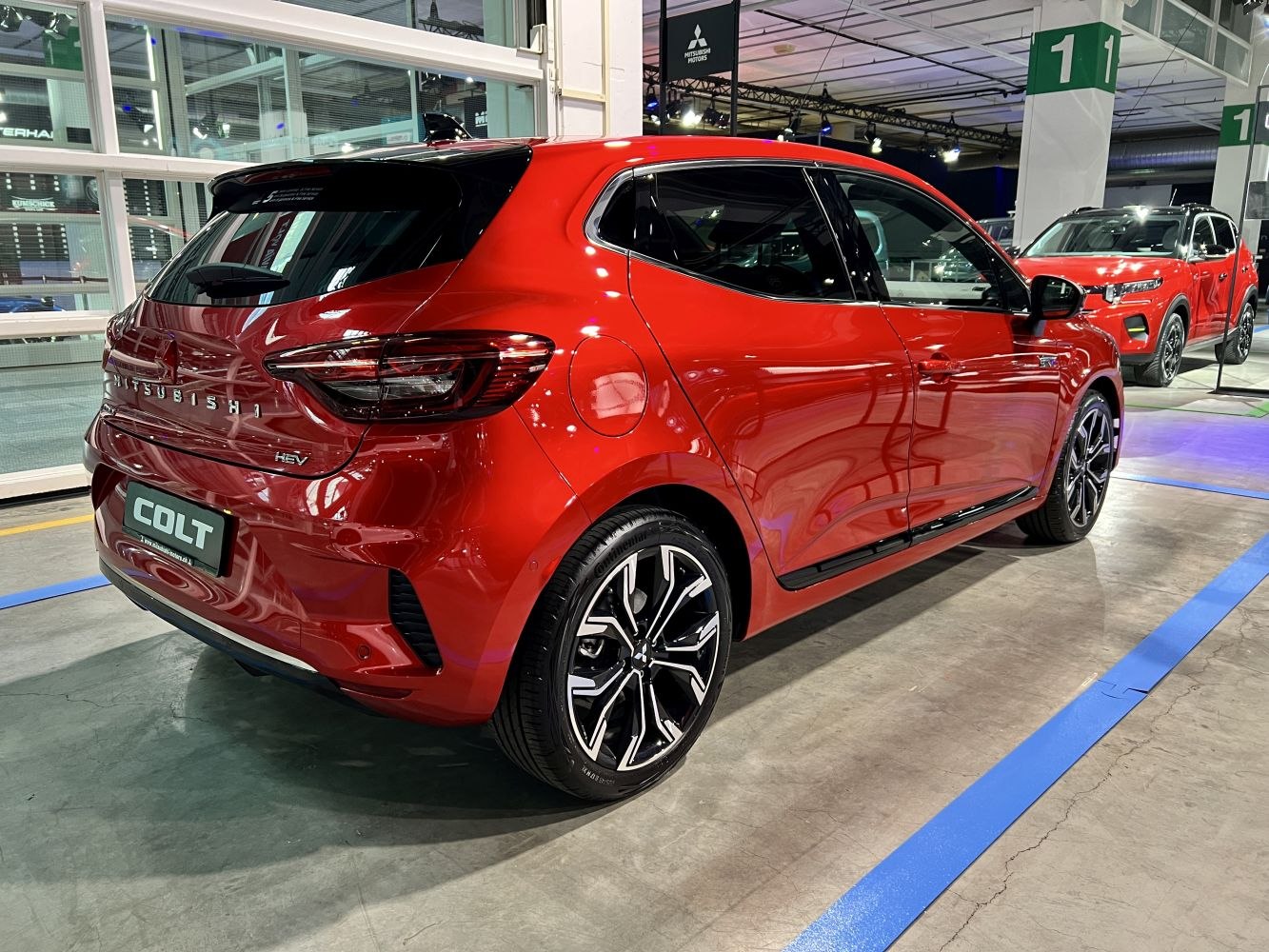 Rear and side view of sleek red hatchback with modern tail lights and sporty alloy wheels