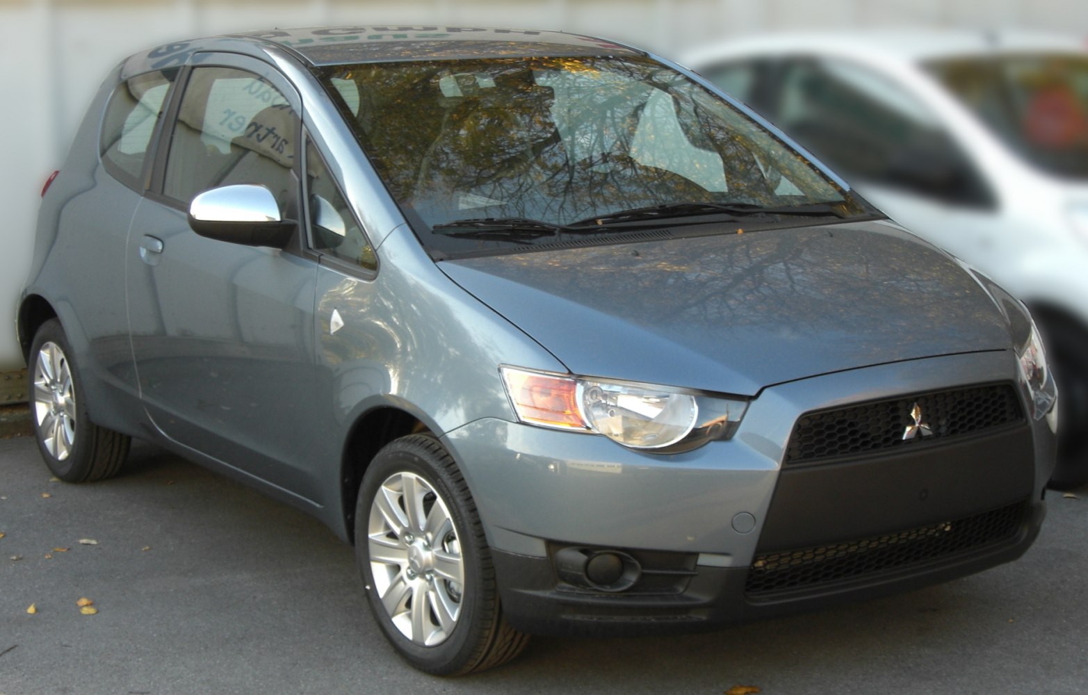 Front side view of 3-door hatchback with headlights and alloy wheels