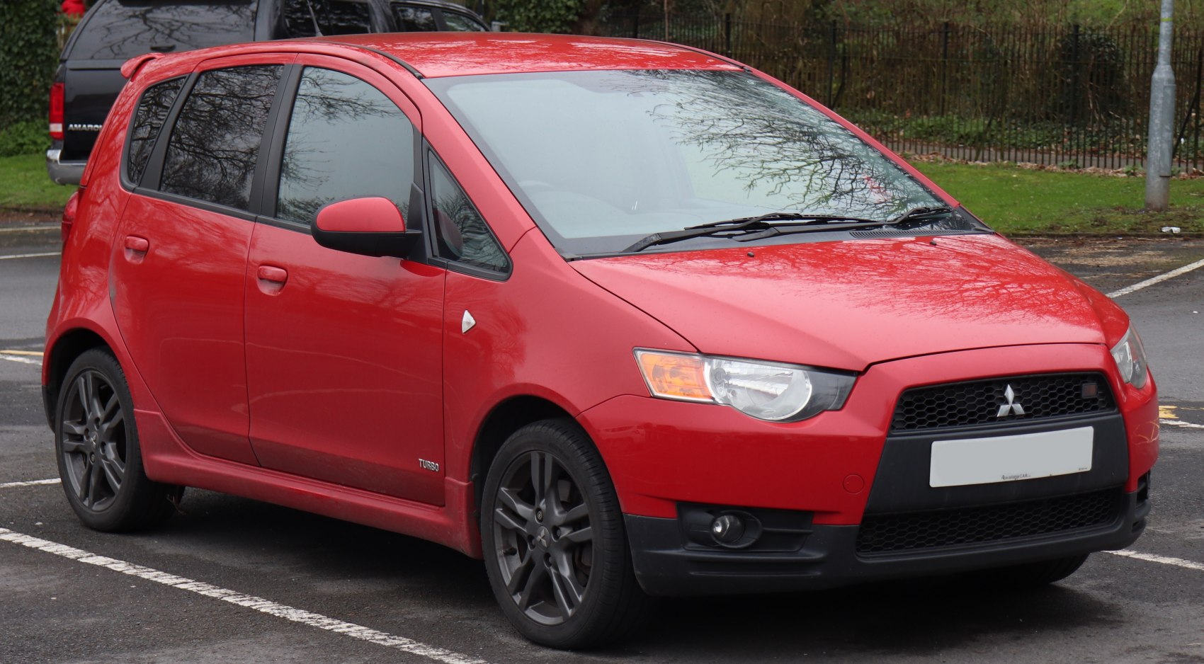 Red hatchback with turbo badge, front and side view