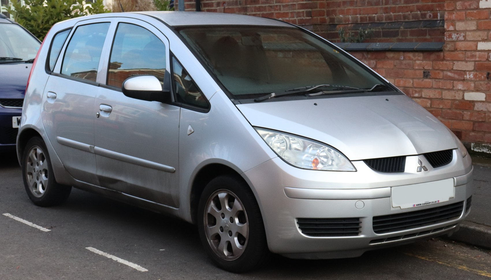 Silver 5-door compact hatchback with unique headlights and grille
