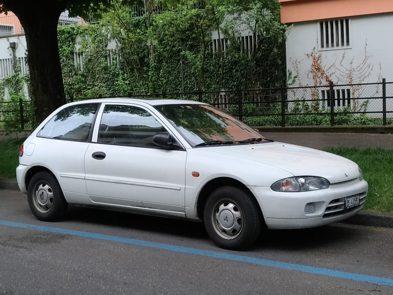 White compact hatchback with rounded front and small hubcaps