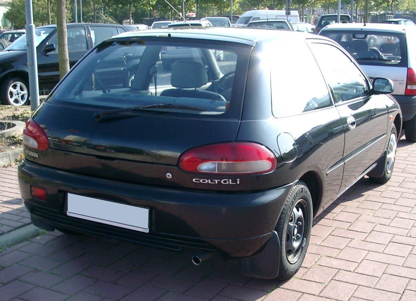 Rear view of compact hatchback with rounded tail lights and black bumper