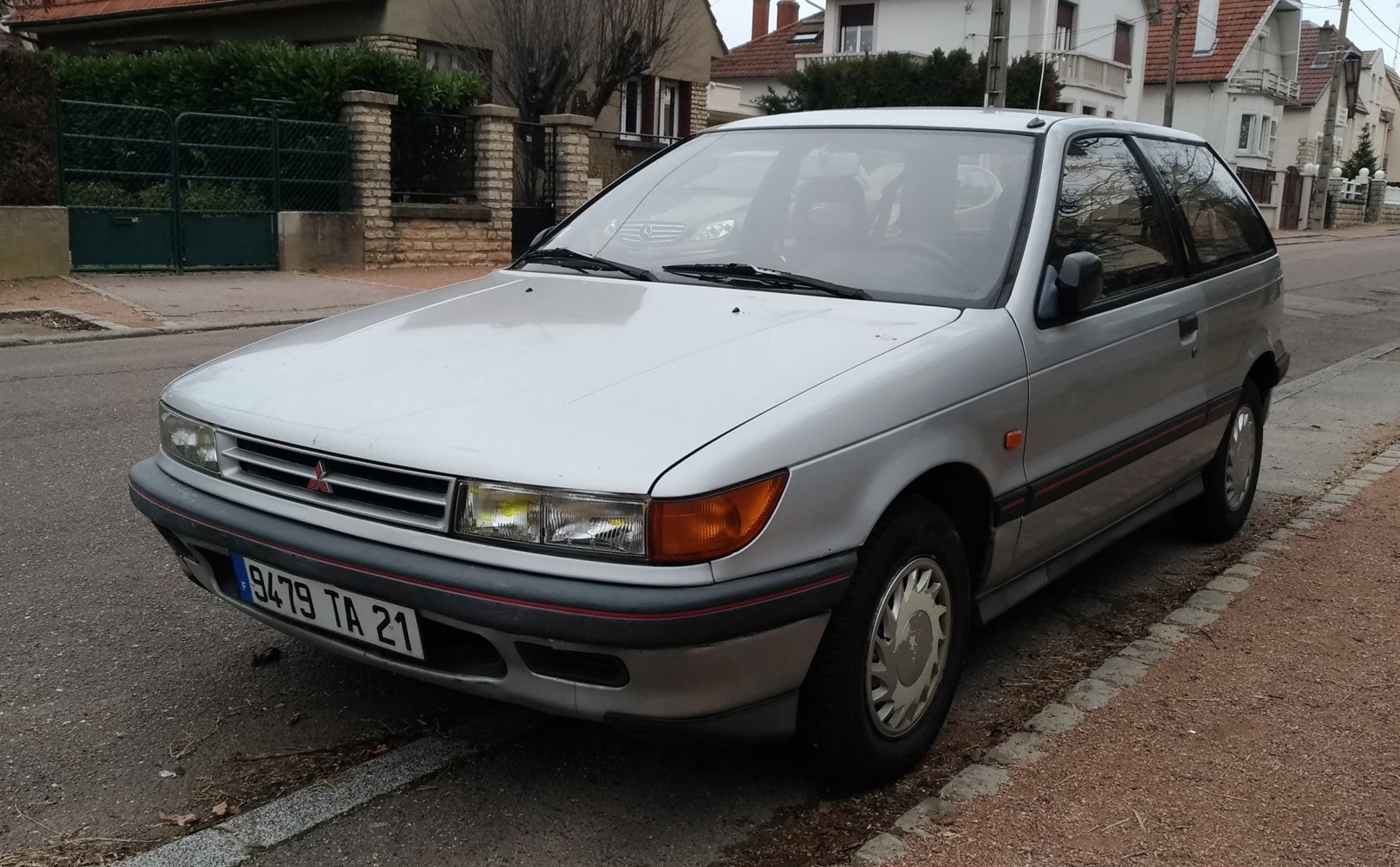 Front and side view of a vintage three-door hatchback.