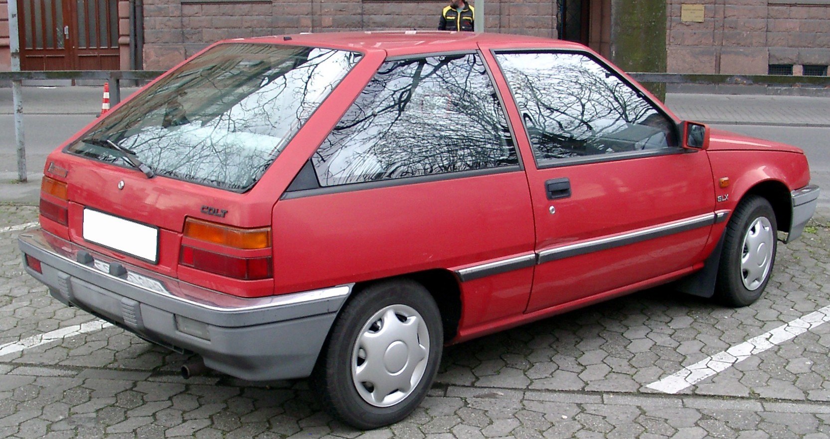 Rear side perspective of an angular hatchback with visible wheel and rear lights.
