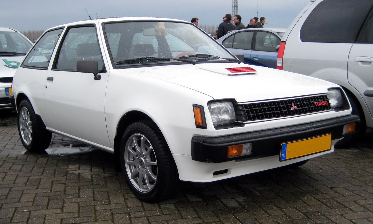White vintage hatchback with turbo vent on hood and black bumper