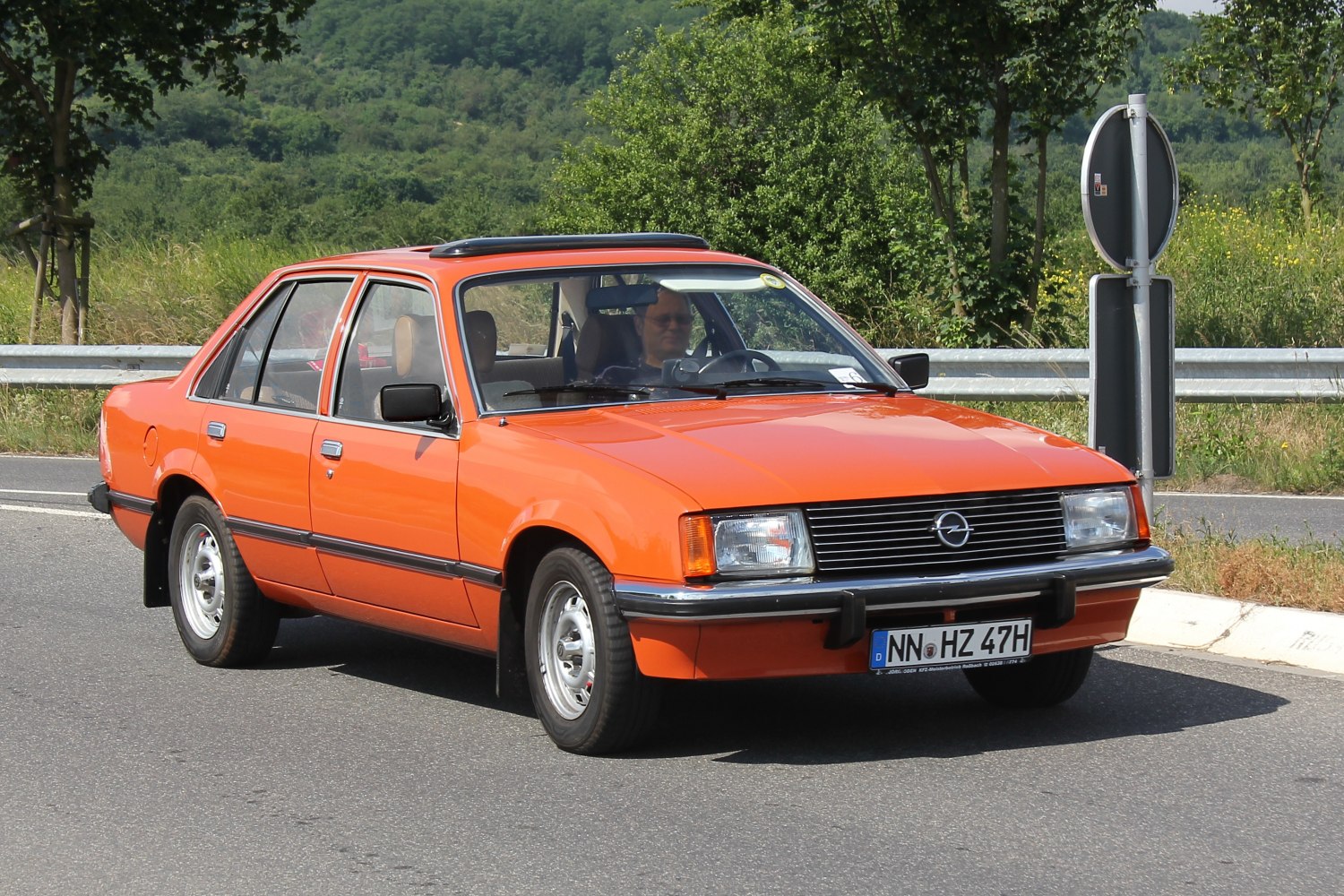 Front-side view of classic mid-size sedan with sunroof on road