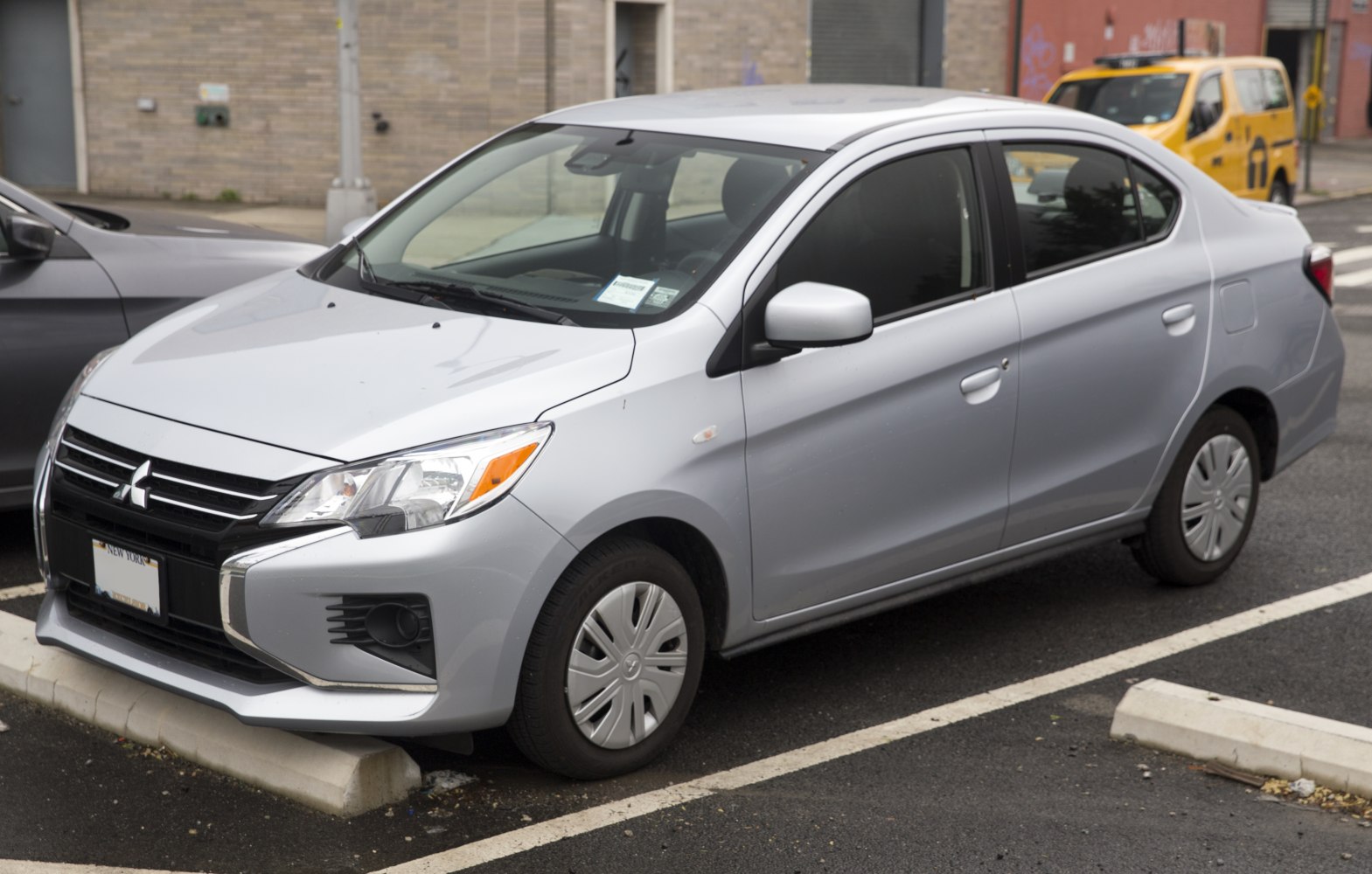 Compact silver sedan with facelifted grille and modern headlights