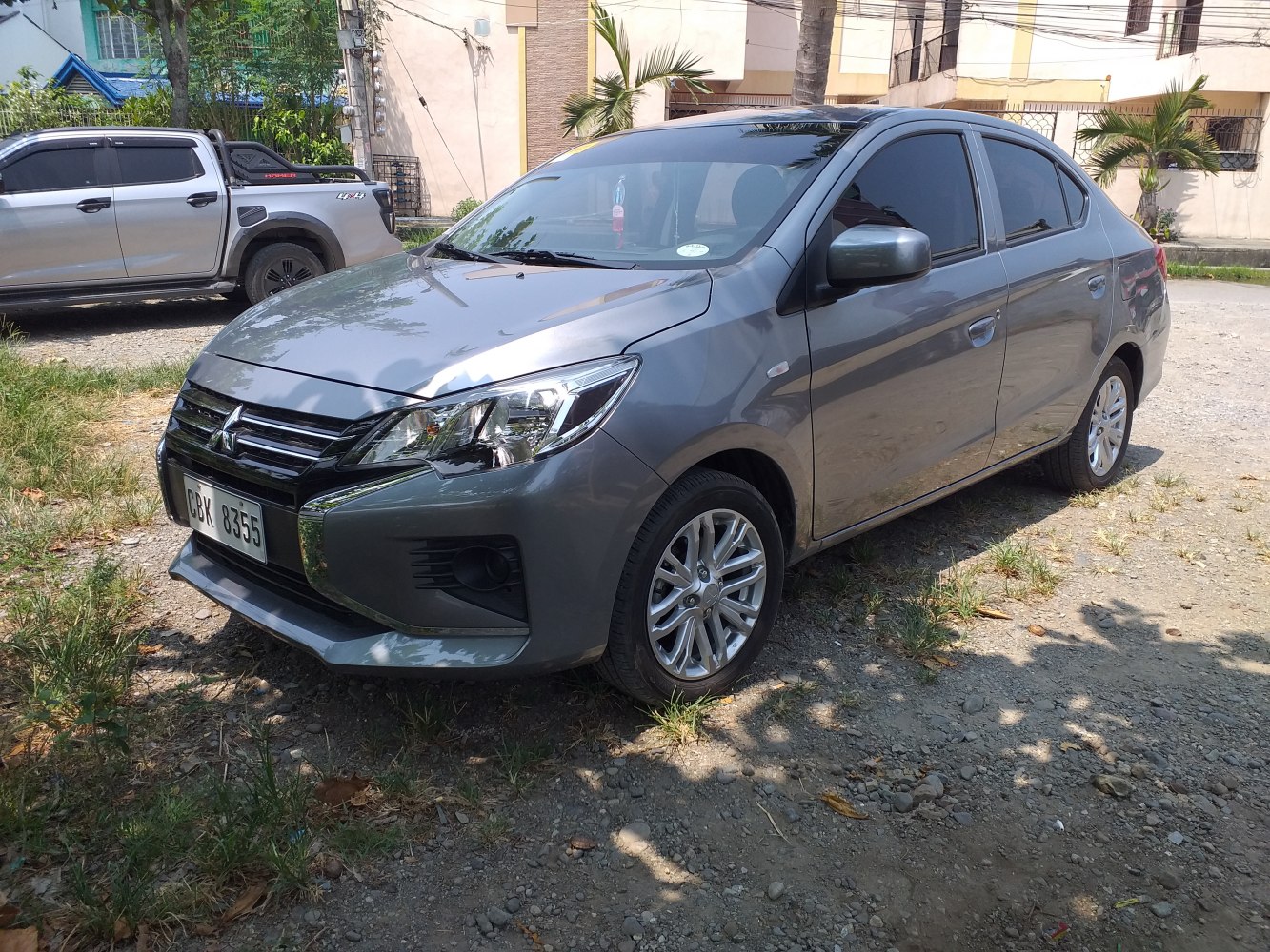 Front and side view of gray compact sedan with alloy wheels and sleek headlights.