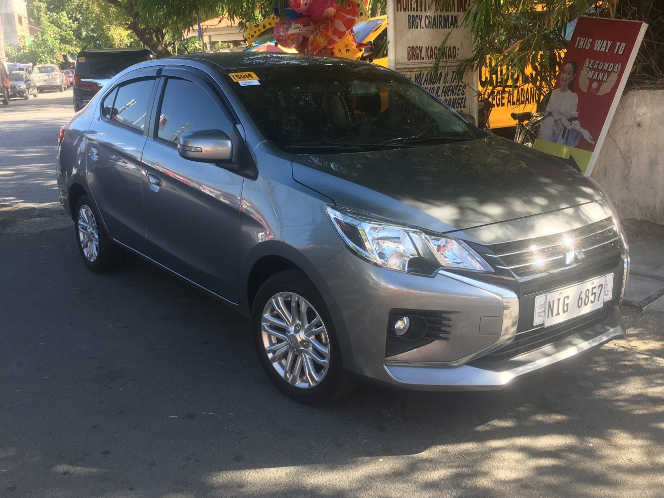 Silver compact sedan with sleek headlights, alloy wheels, and tinted windows.