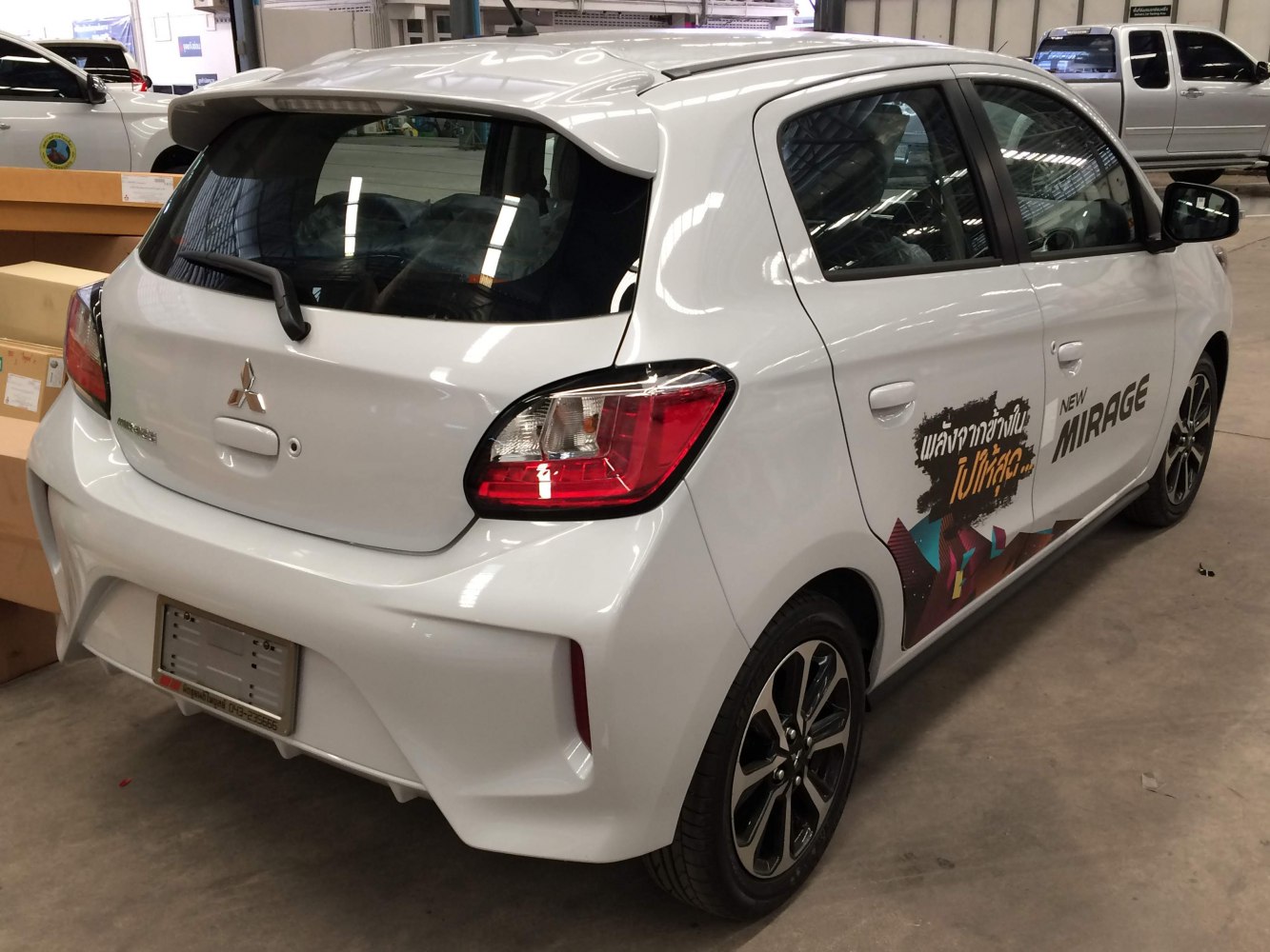 Rear and side view of white hatchback with alloy wheels and rear spoiler