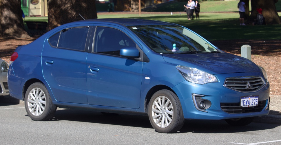 Blue compact sedan front side view with alloy wheels and sleek headlights
