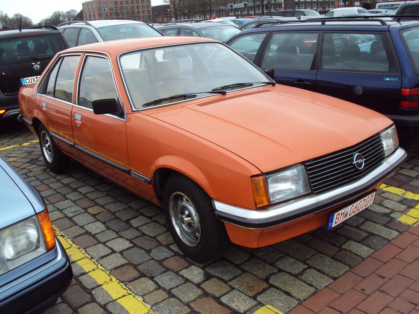 Orange vintage four-door sedan with rectangular headlights and horizontal grille