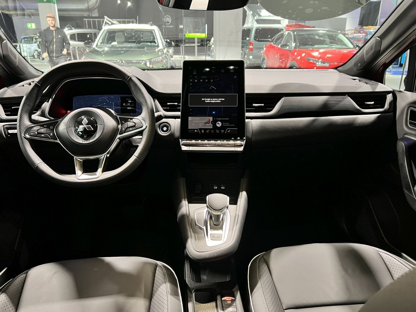 Digital instrument cluster and vertical touchscreen infotainment with steering wheel controls.