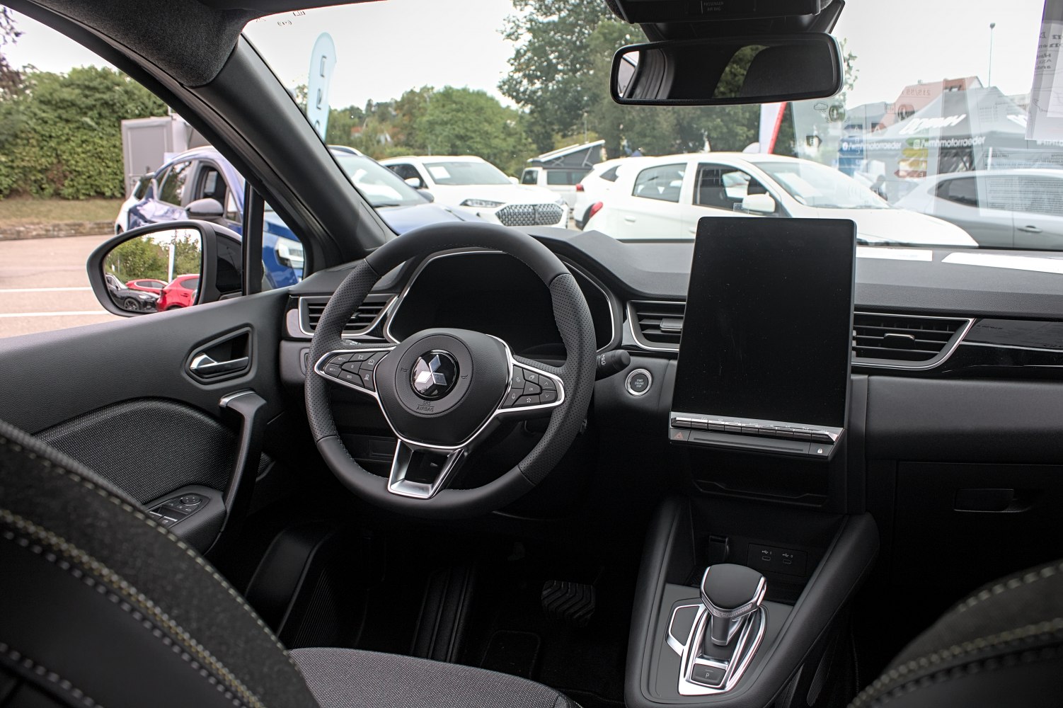 Modern steering wheel and large vertical touchscreen display in car interior