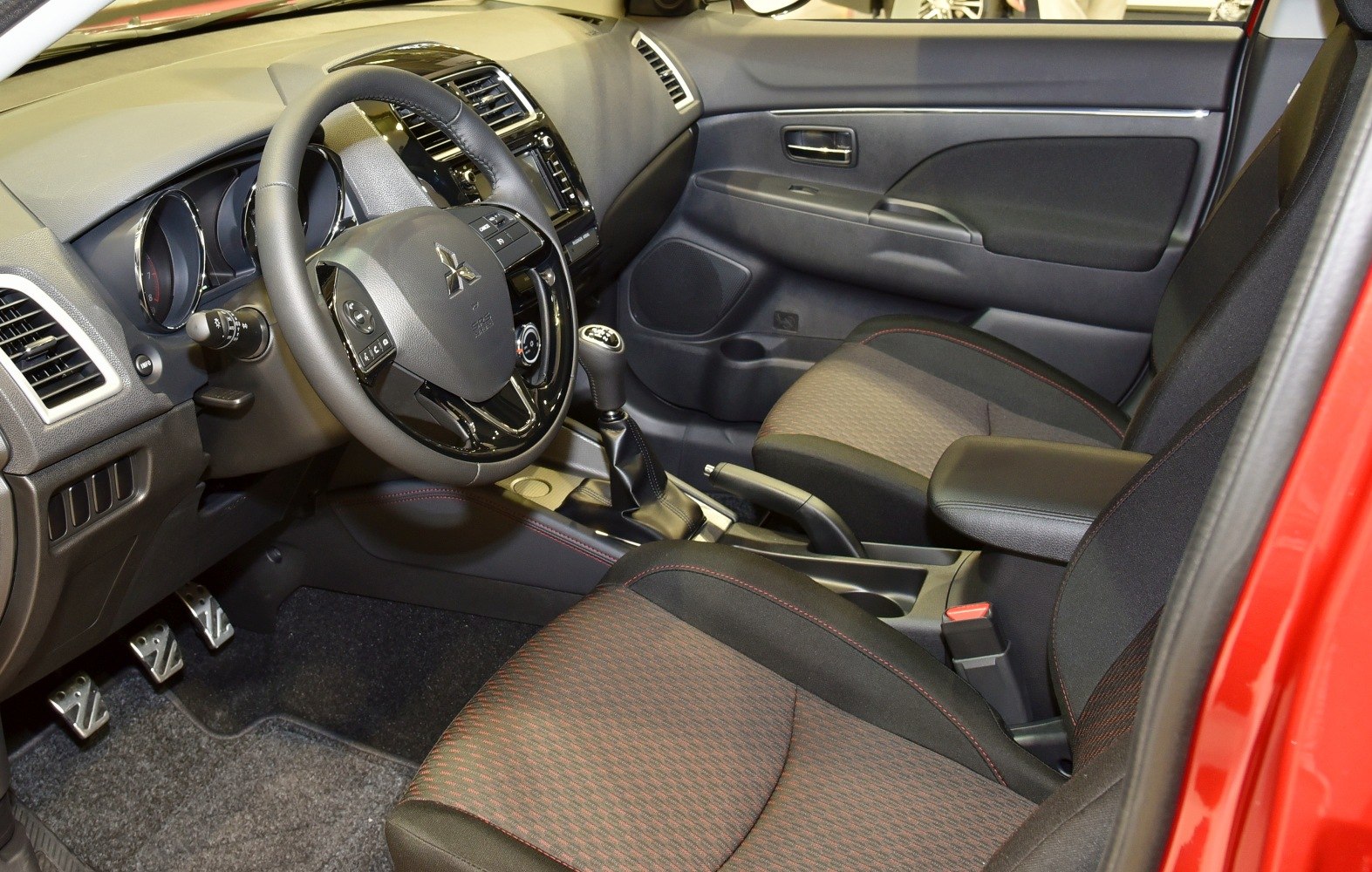Dashboard, steering wheel, gear shift, and front seats with upholstery details