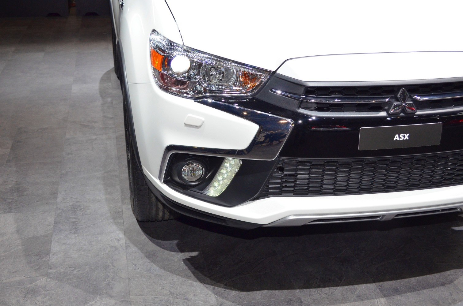 Front grille and headlight close-up with fog light and bumper details