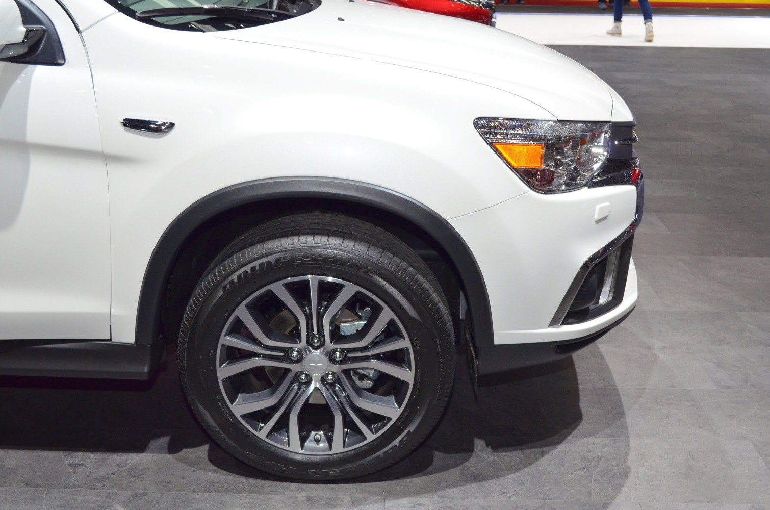 Front wheel with alloy rim and headlight close-up