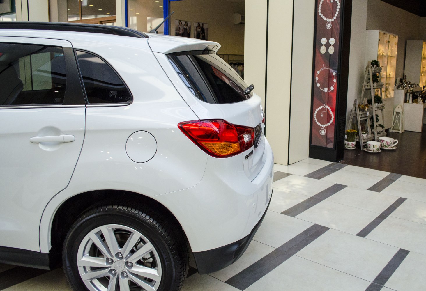 Rear section showing taillights, alloy wheel, and rear spoiler