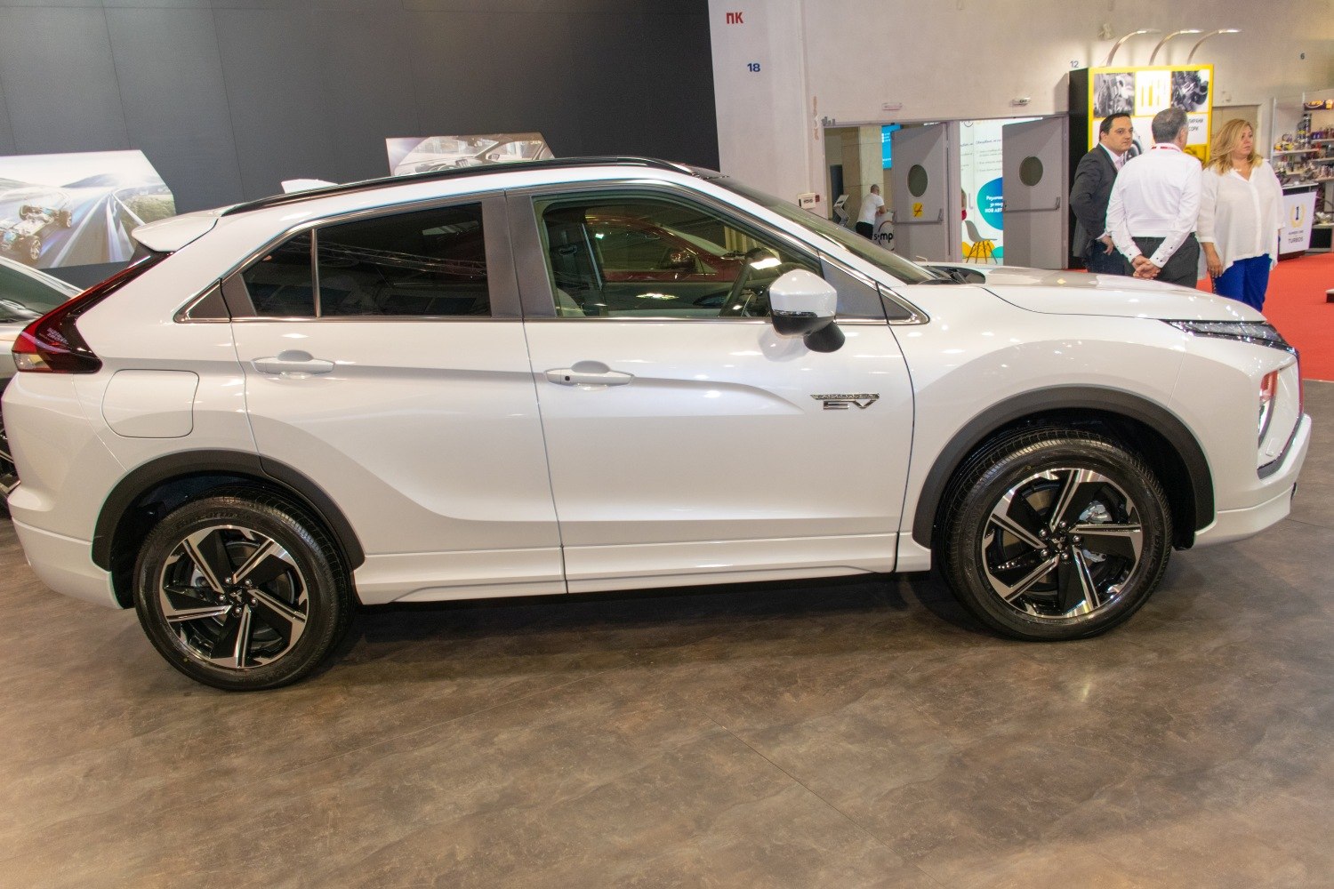 Side profile of a white compact SUV with EV badge and alloy wheels