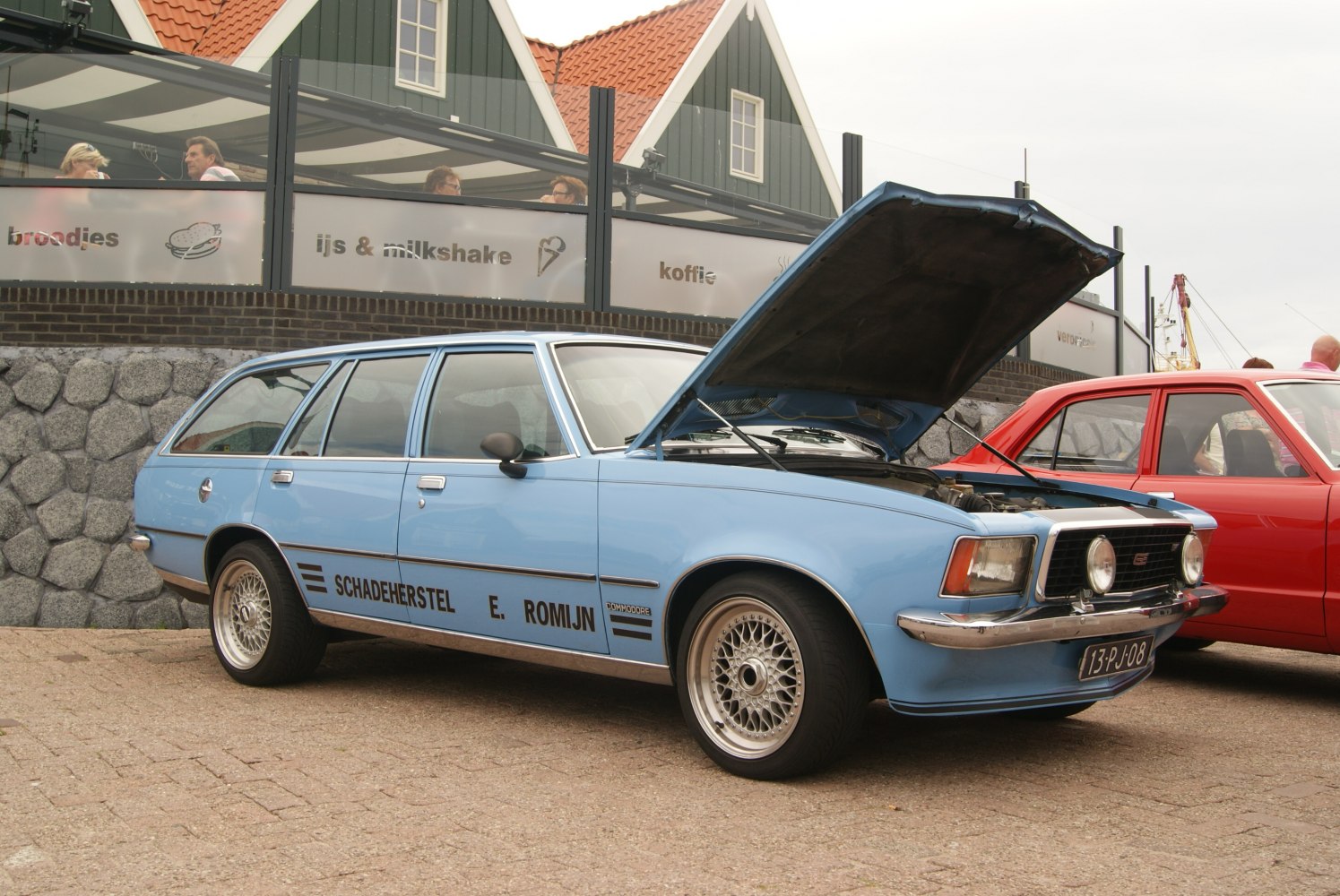 Blue station wagon with open hood and alloy wheels