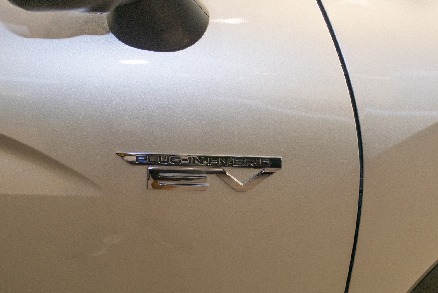 Close-up of plug-in hybrid EV badge on vehicle side panel