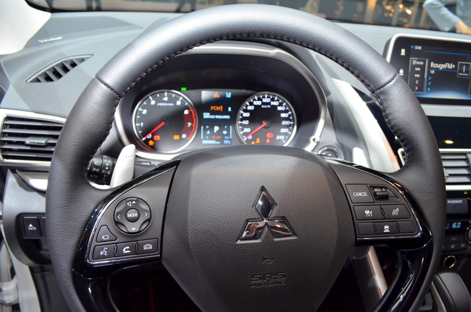 Close-up of steering wheel with mounted controls and dashboard instrument cluster