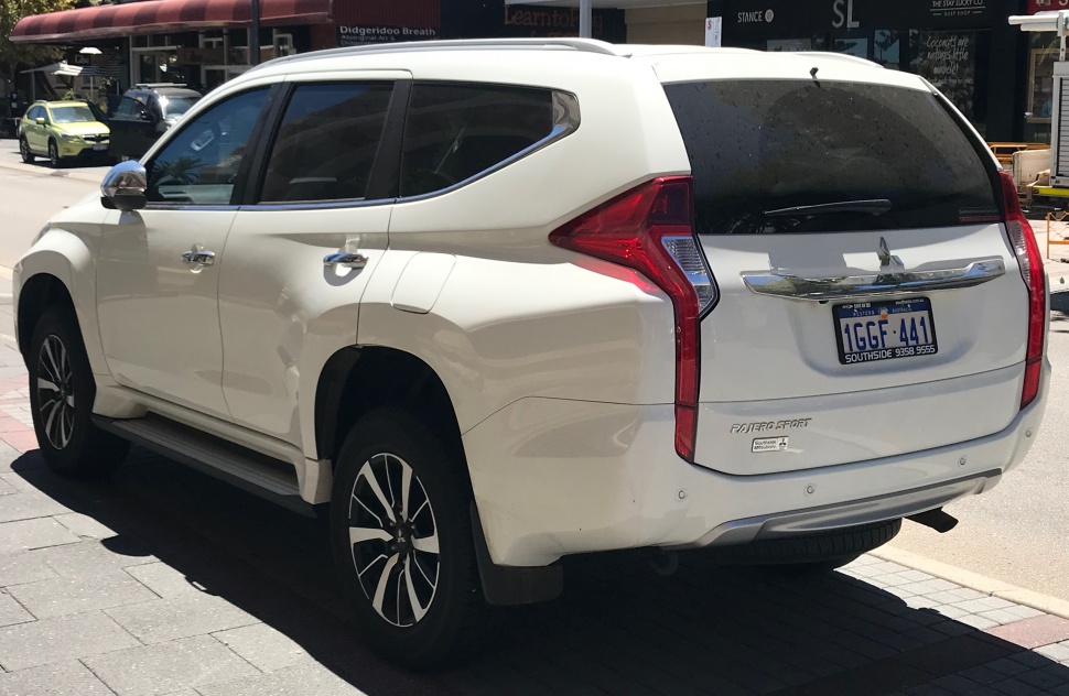 White SUV rear three-quarter view with distinctive vertical taillights and alloy wheels