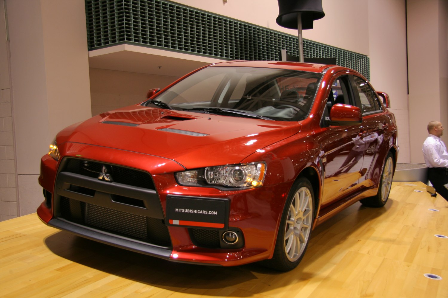 Red sport sedan with aggressive front grille and hood vents