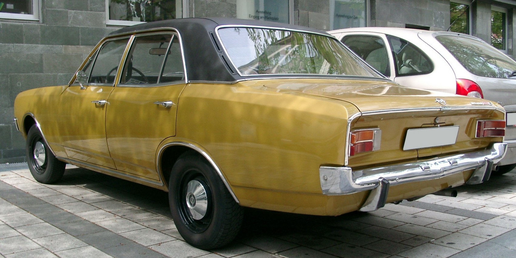 Yellow four-door sedan with black vinyl roof and chrome rear bumper