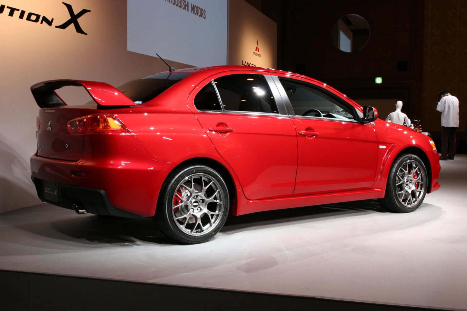 Sporty sedan rear side with large spoiler and alloy wheels