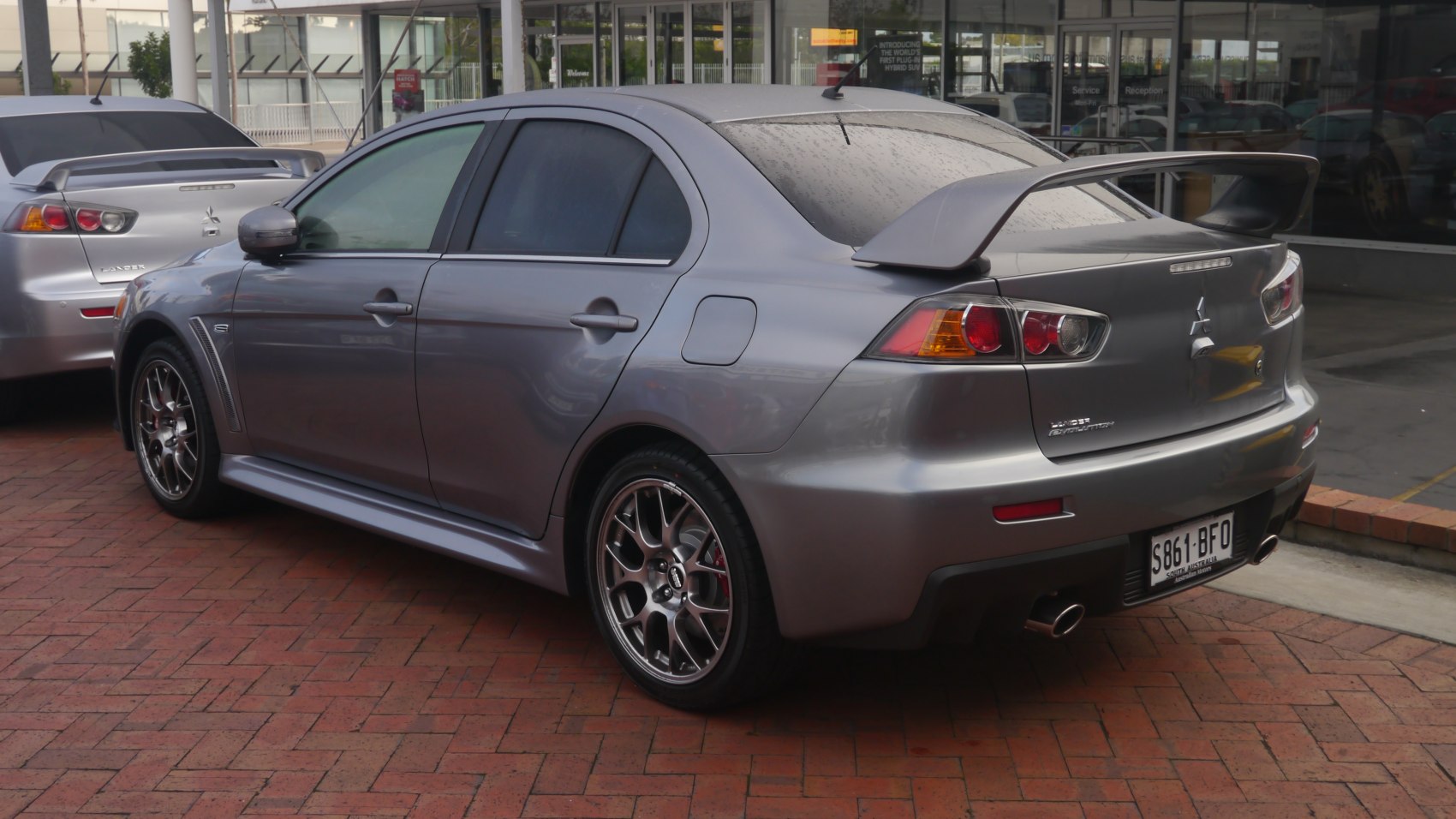 Rear side view with large spoiler and sporty alloy wheels