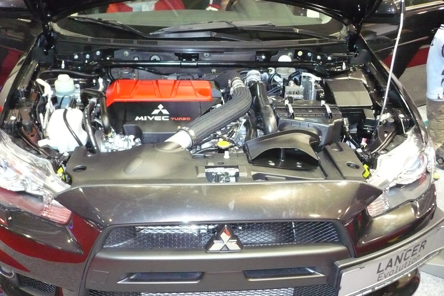 Engine bay of a car with visible MIVEC turbo system and intake piping