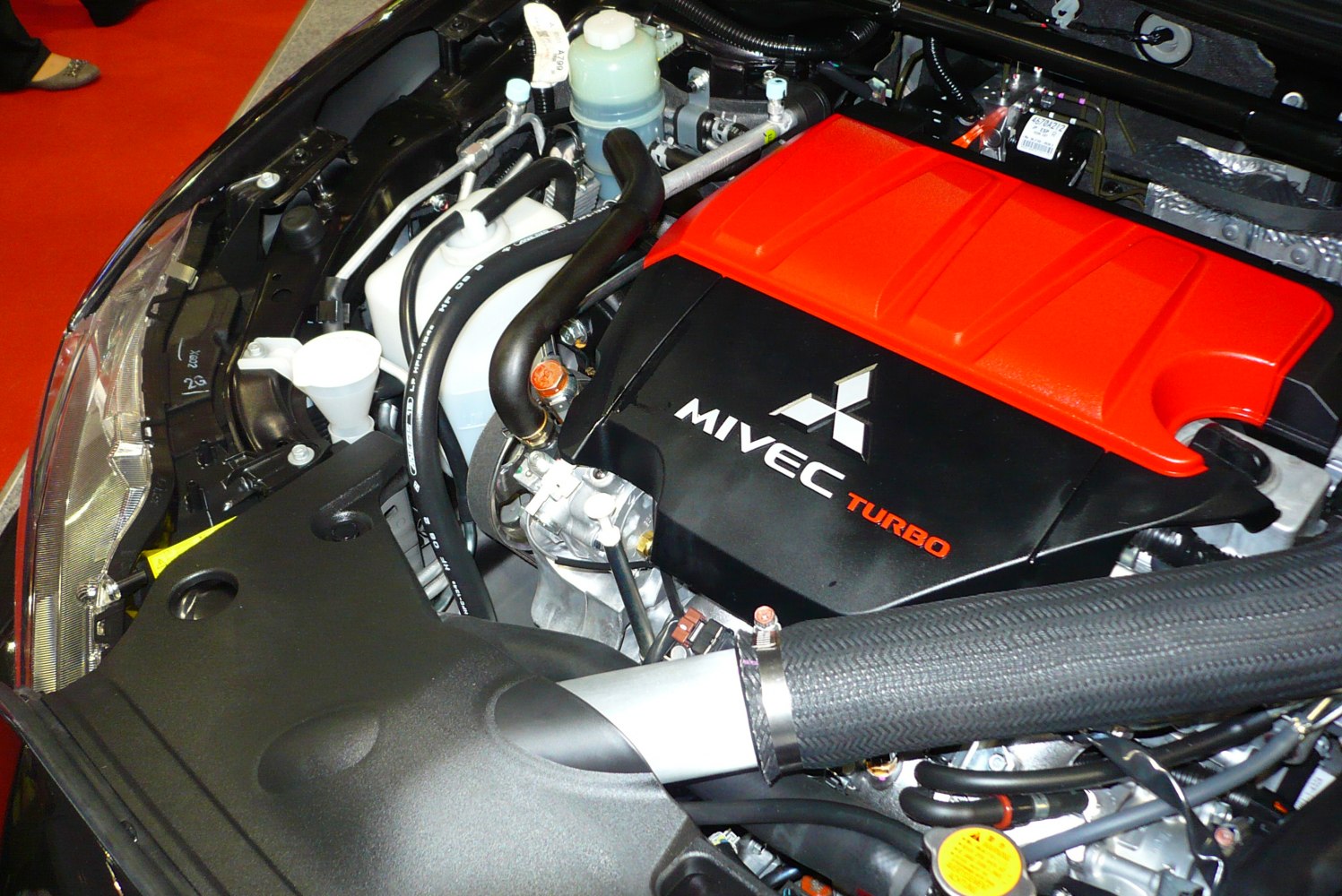 Turbocharged MIVEC engine with distinctive red engine cover and intake pipe