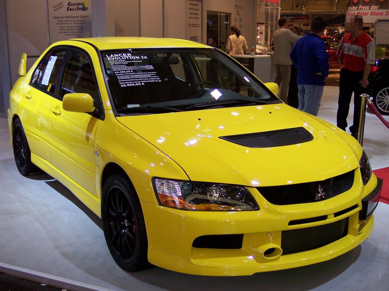 Yellow sports sedan front with hood scoop and black wheels