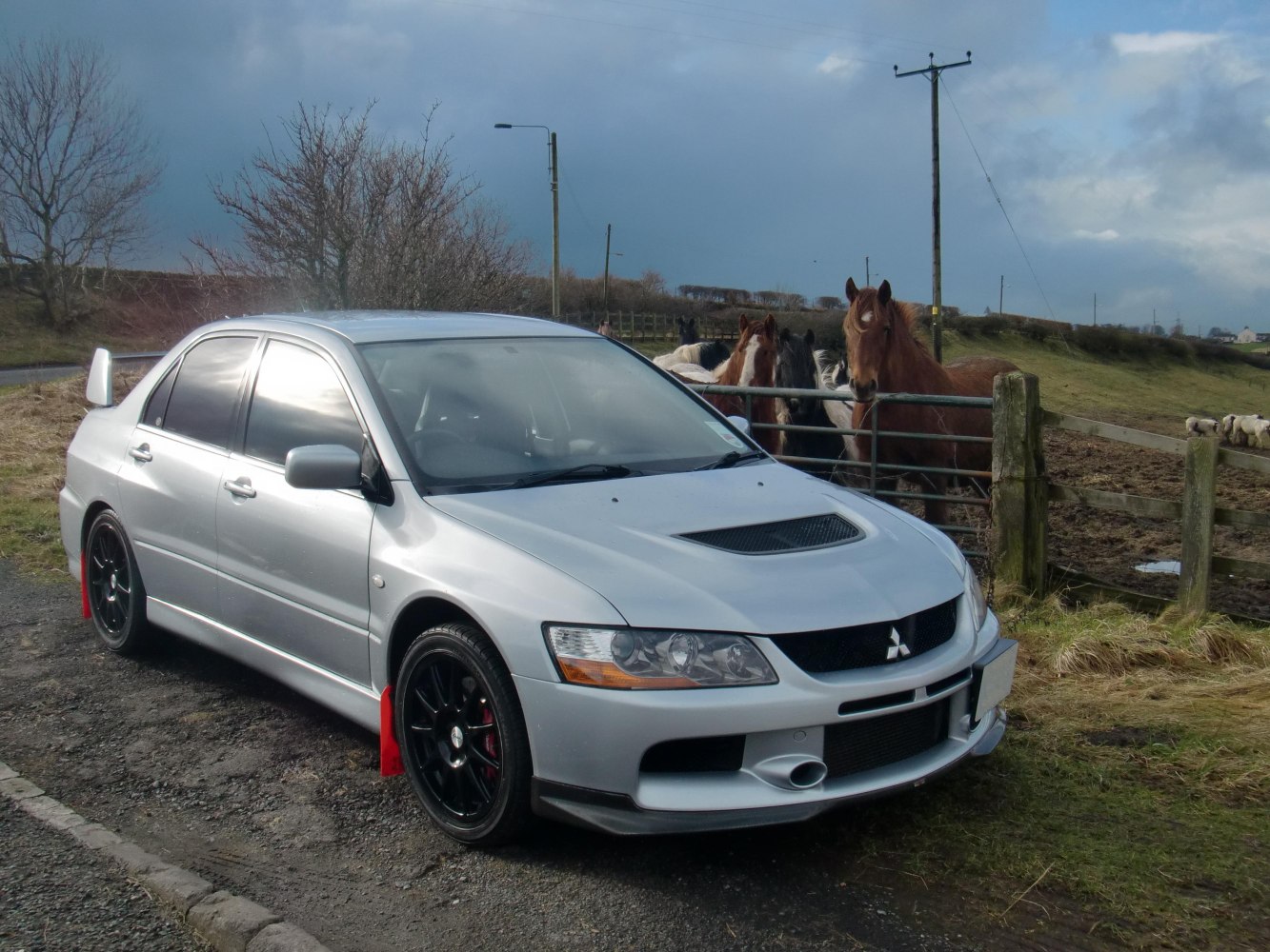 Silver performance sedan with hood scoop and black alloy wheels