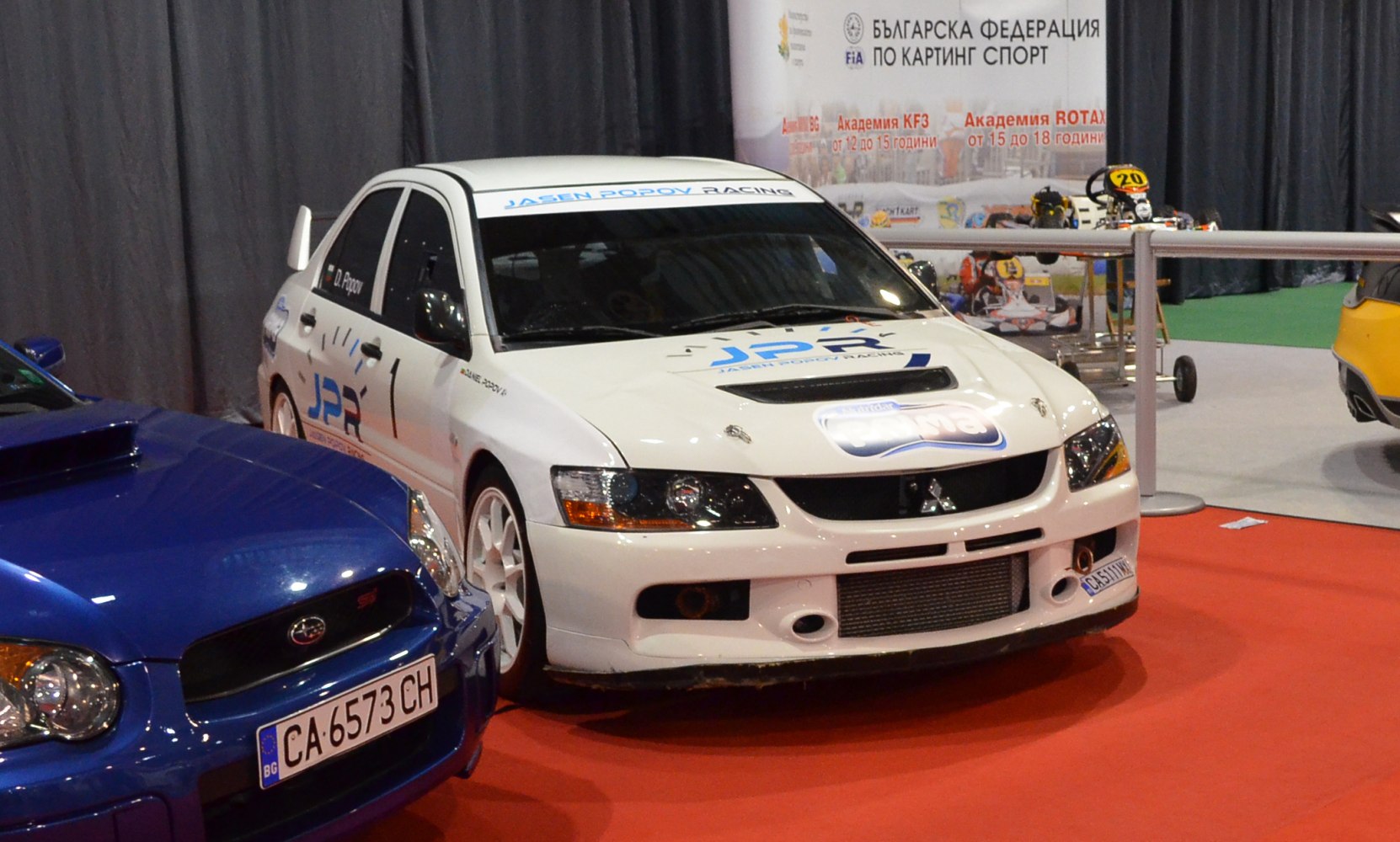 White racing sedan with hood scoop and aggressive front bumper