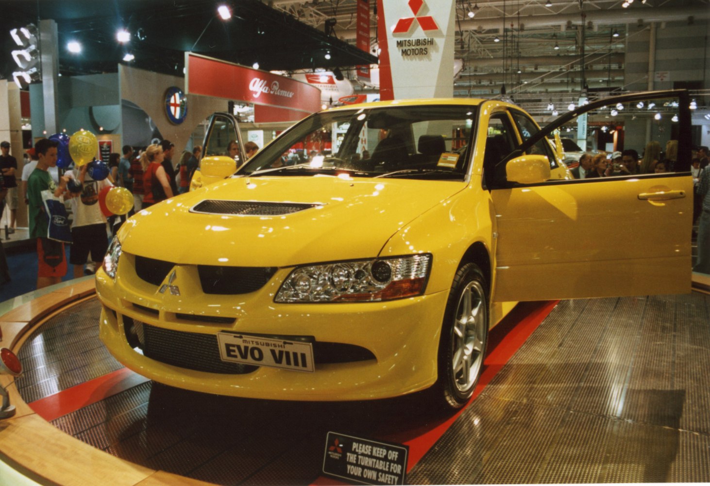 Yellow sporty sedan front with hood scoop and open driver's door