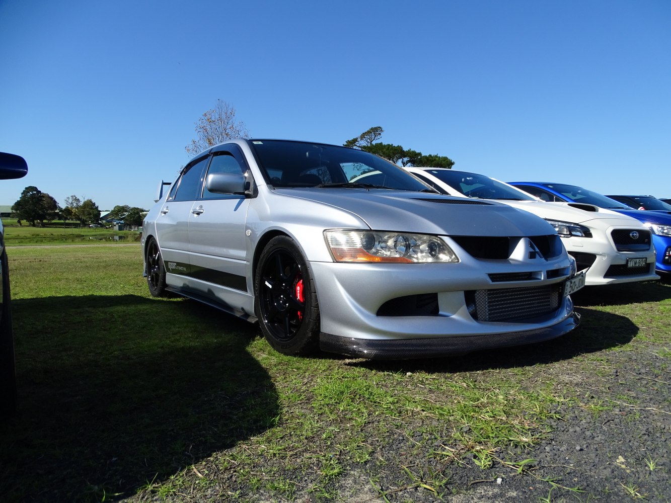Silver sporty sedan front-side with black wheels and red brake calipers