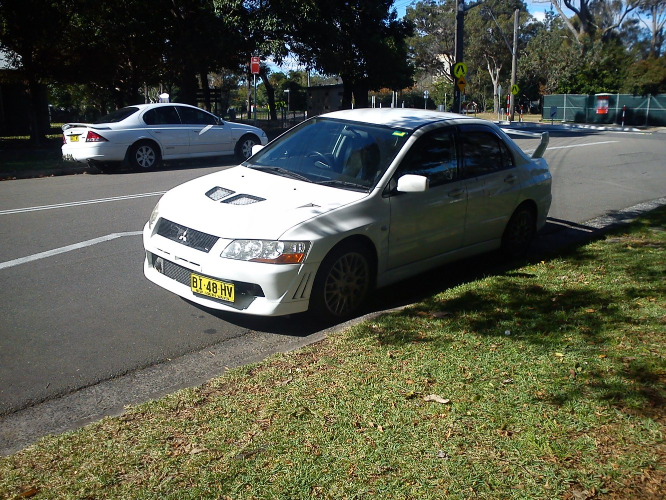 White sedan with hood vents and large rear spoiler