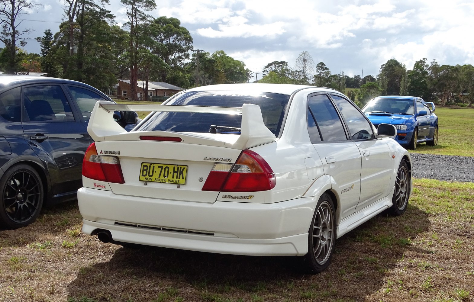White car with large rear spoiler and alloy wheels