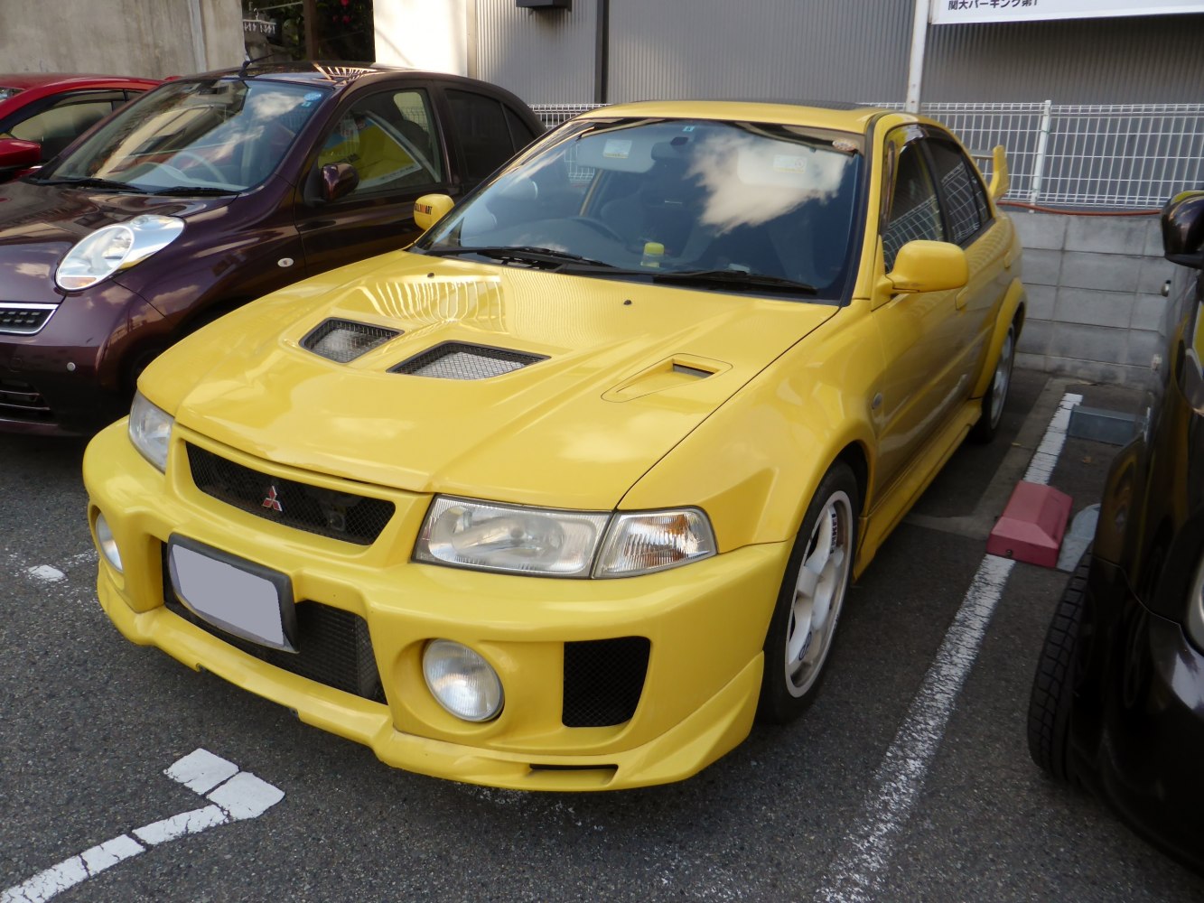 Yellow sports sedan with hood vents and aggressive front bumper
