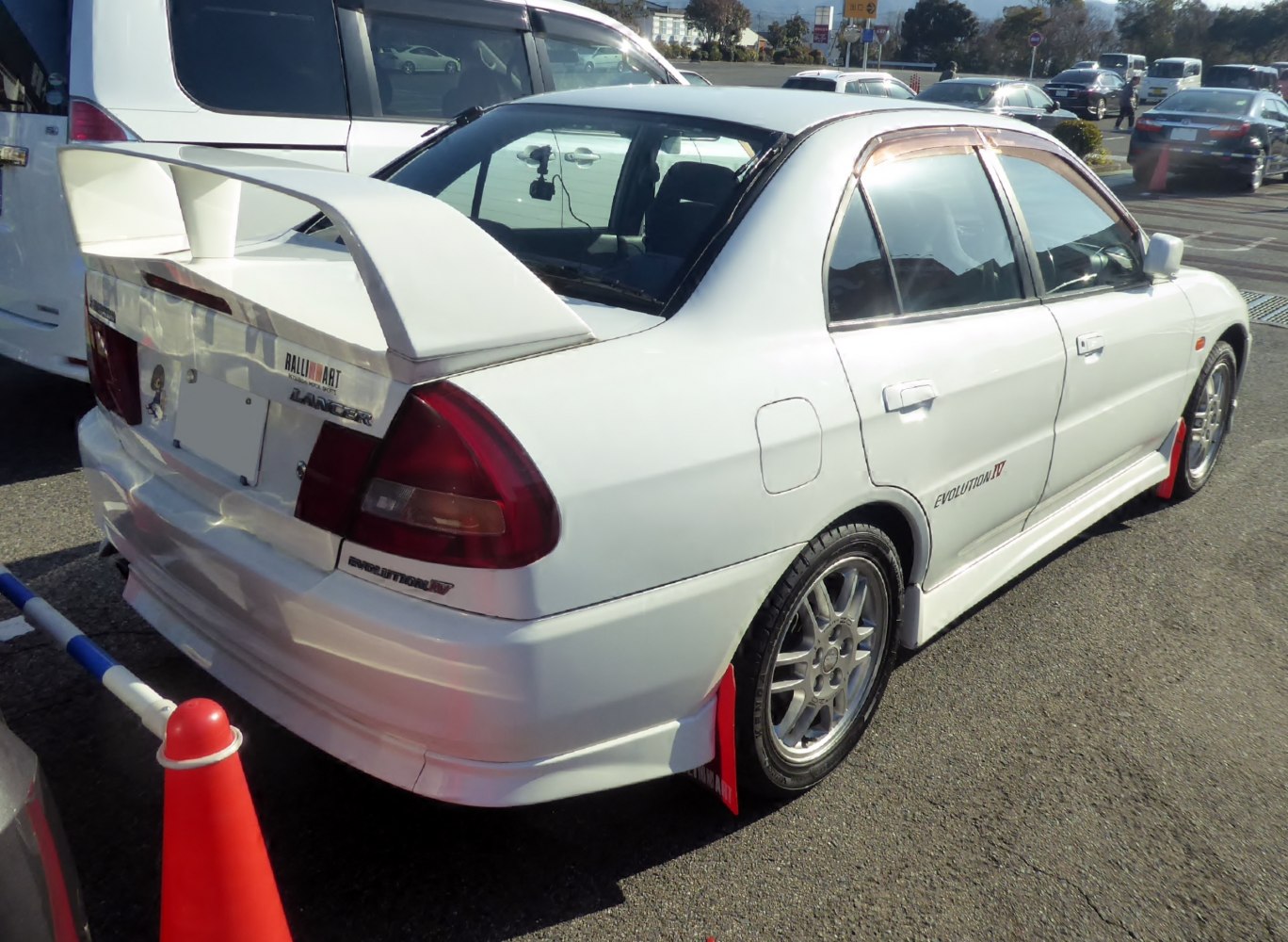 White sedan with large rear wing and red Ralliart mudflaps