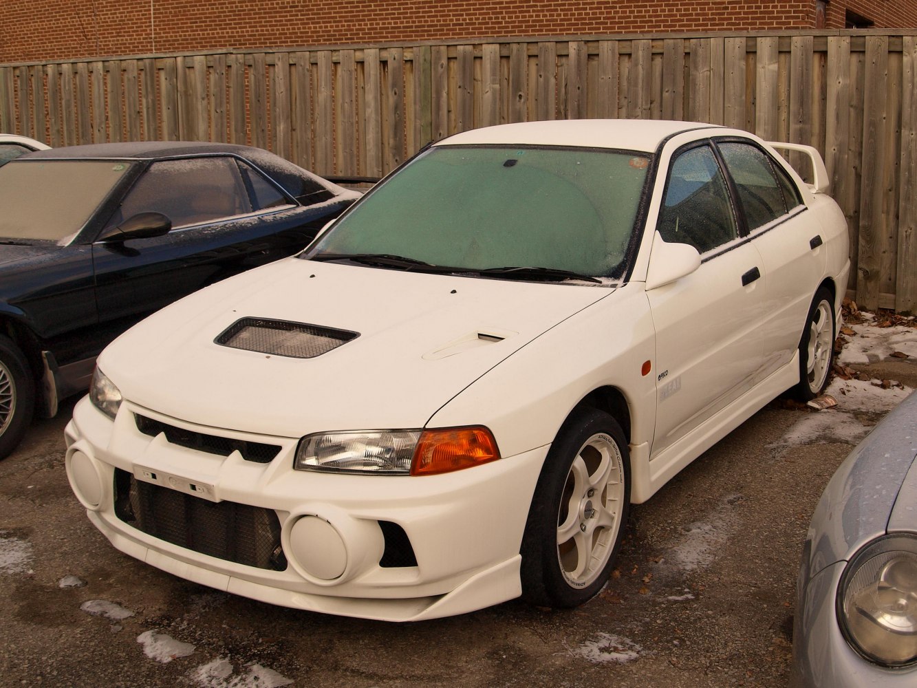 White sedan with prominent hood scoop and aggressive front bumper design