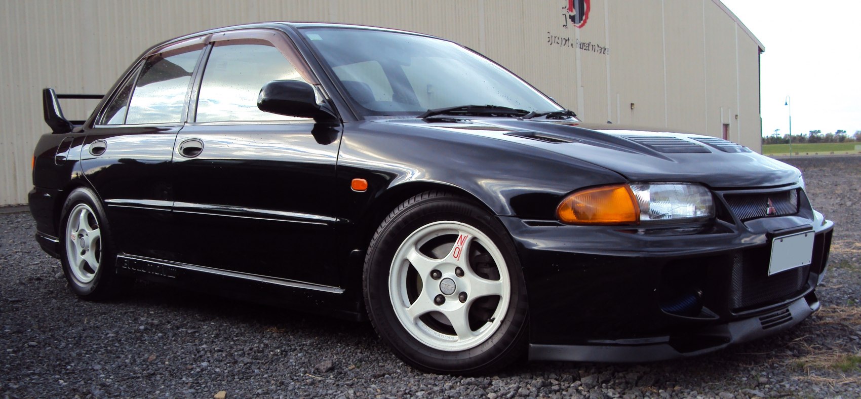 Sporty black sedan with aerodynamic front bumper and racing wheels