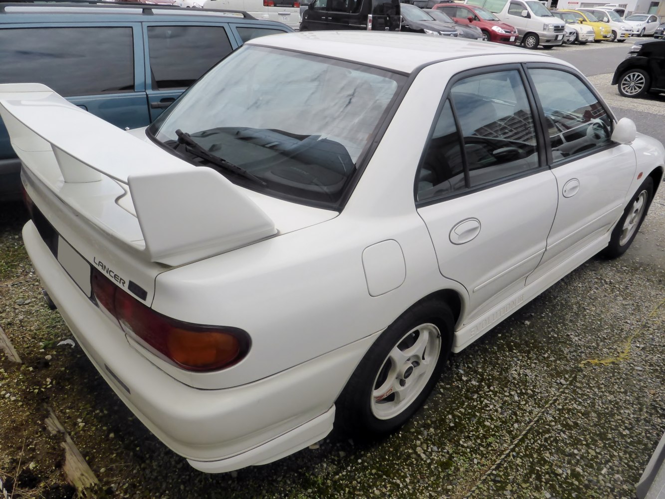 Rear side view with large rear wing and white alloy wheels