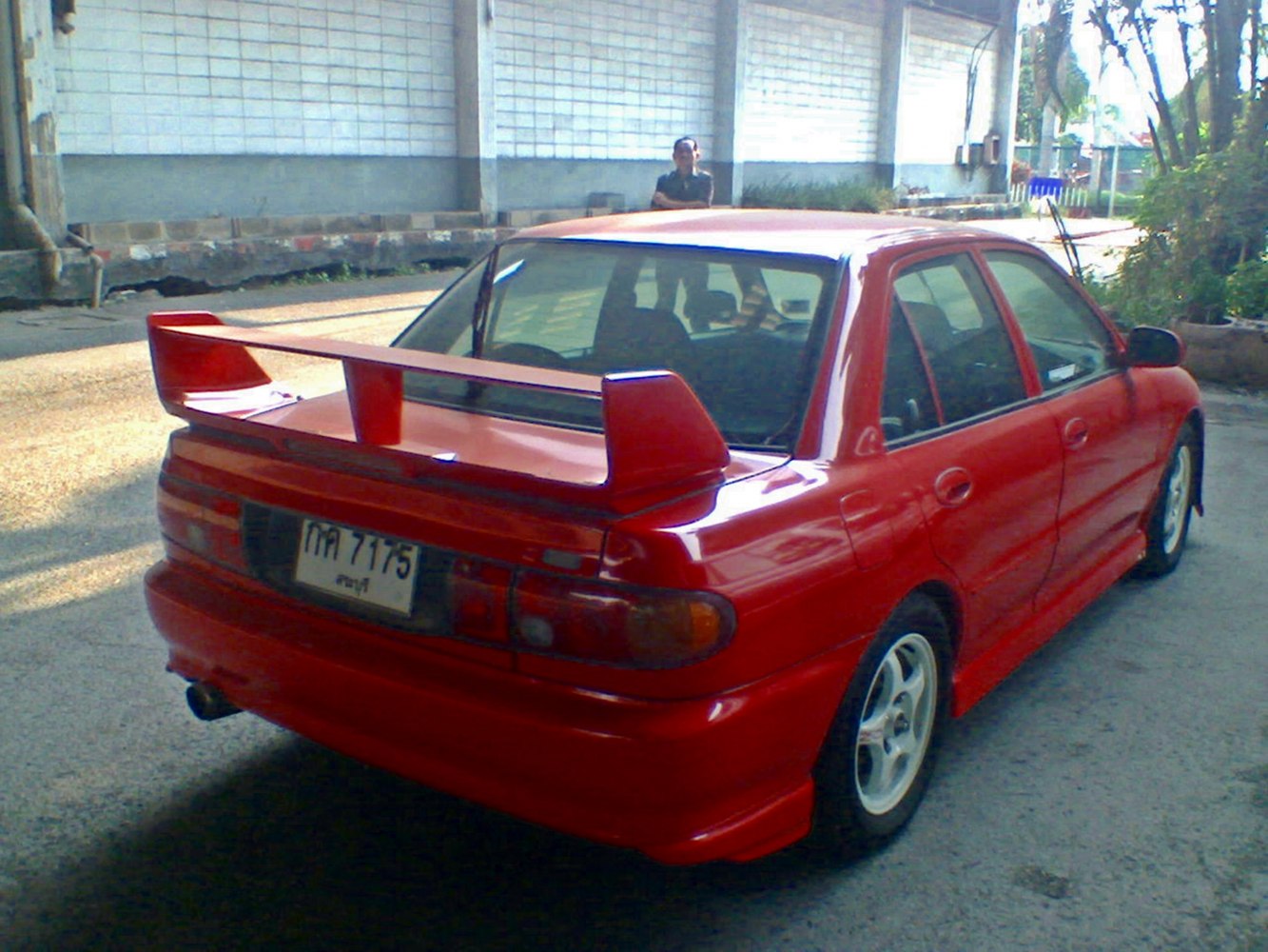 Red sedan with a large rear wing spoiler and prominent side skirts