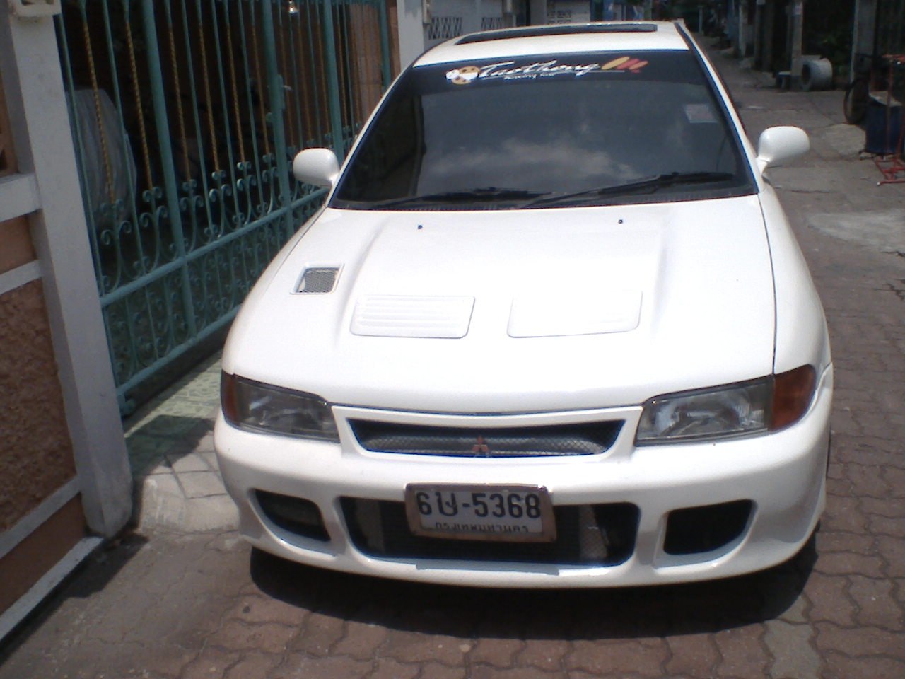 Close-up of car hood with vents and front grille with headlights.