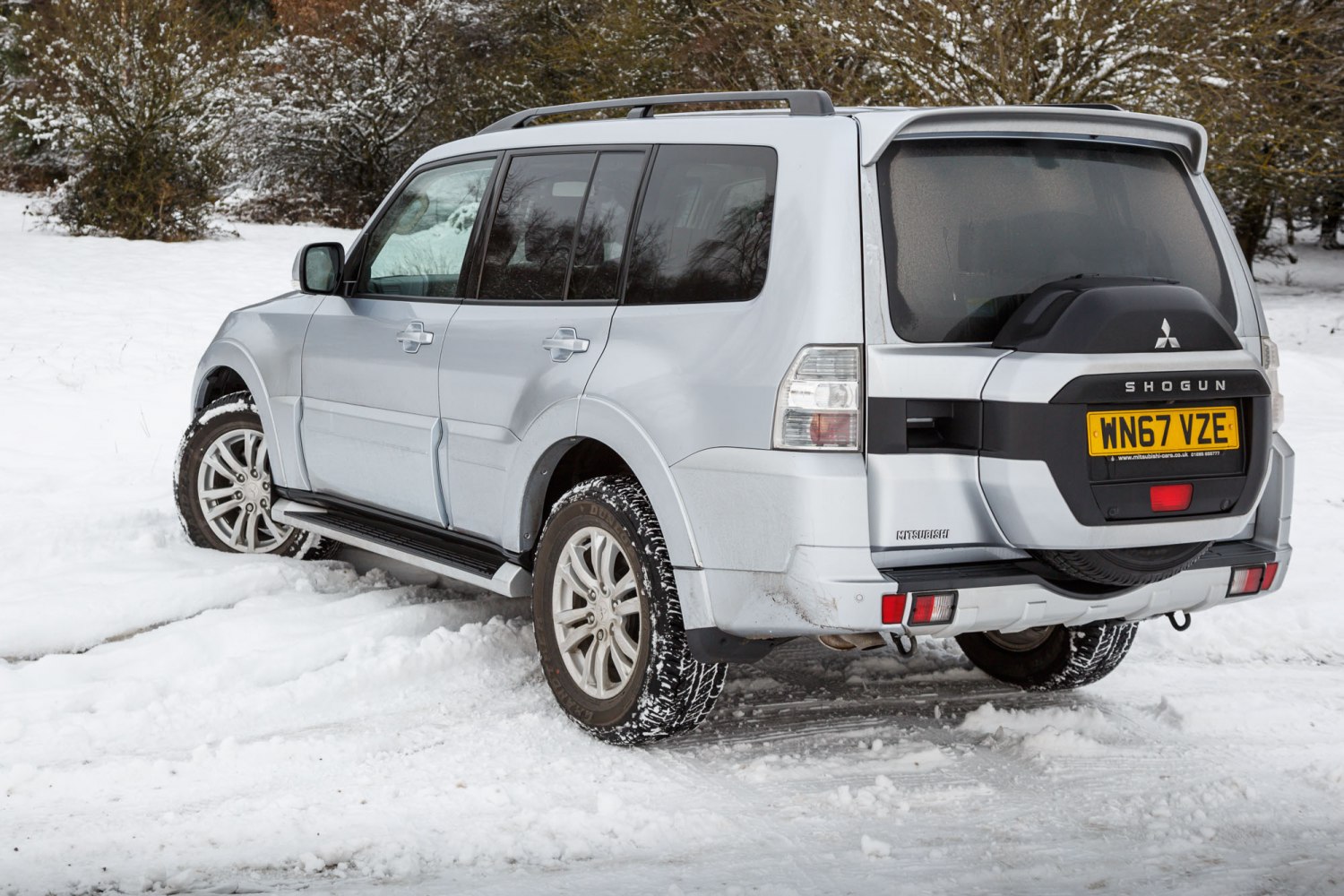 Rear-side view of SUV with spare wheel cover in snowy terrain