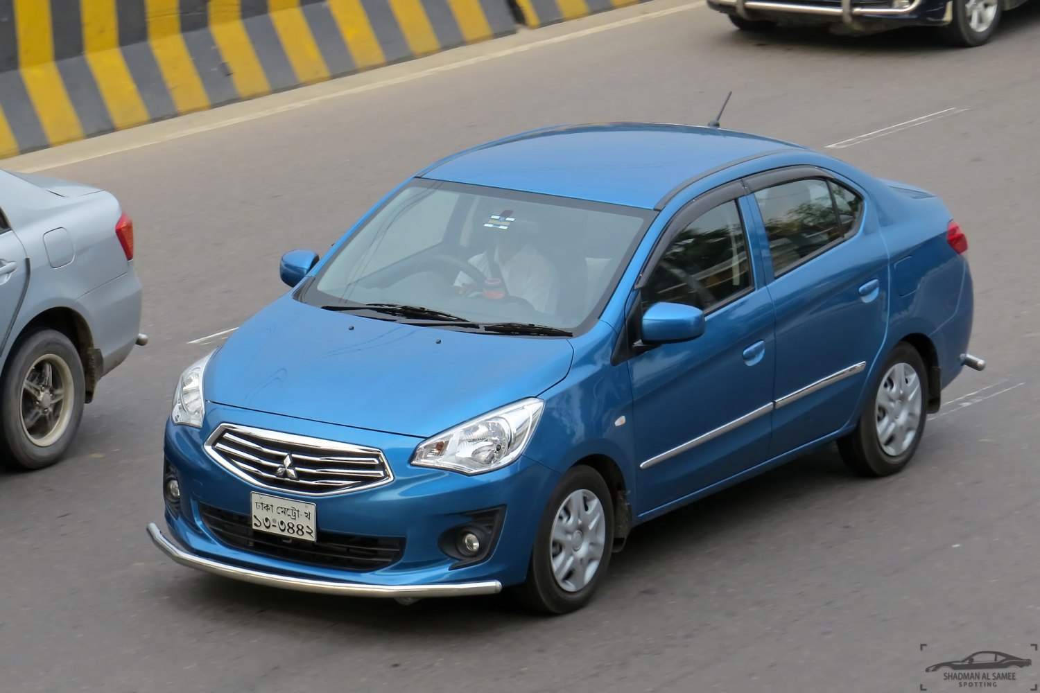 Front three-quarter view of blue compact sedan with distinct grille and headlights