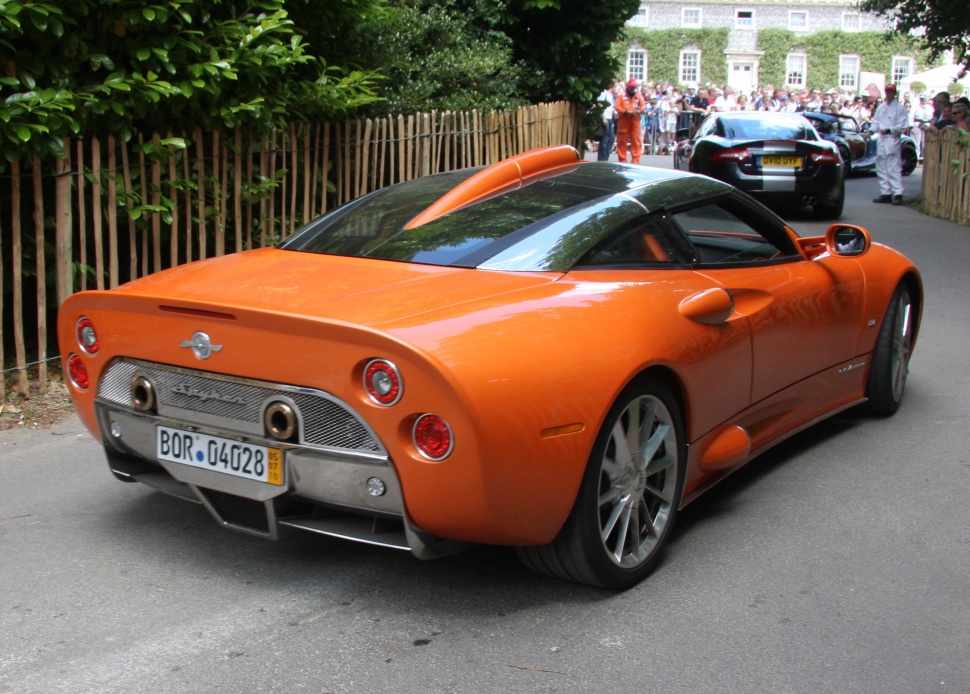 Rear view with dual exhausts, round taillights, orange sports coupe